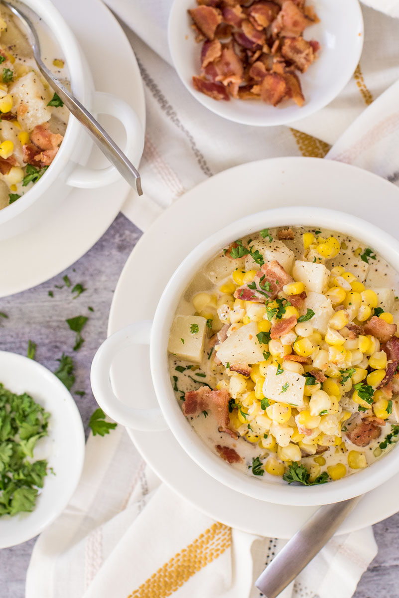 bowls of fresh corn chowder with crumbled bacon and fresh corn