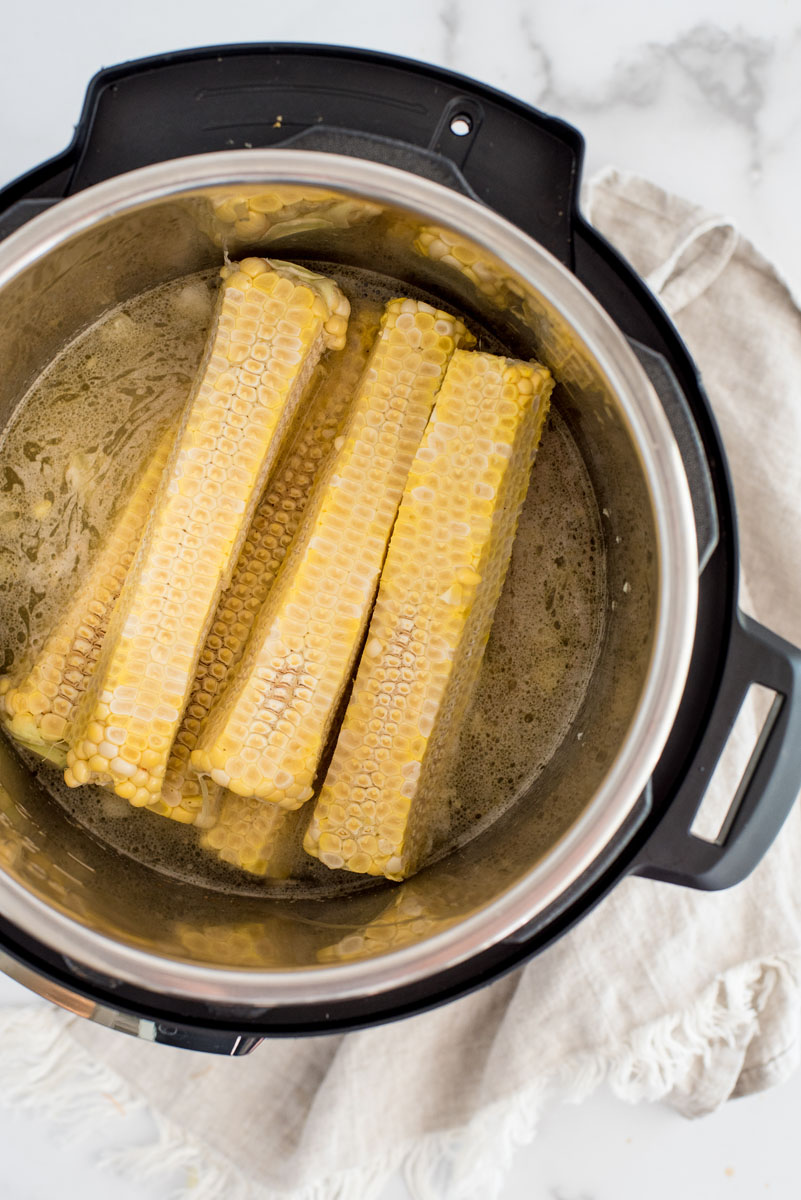 overhead shot of cooking fresh corn cobs in the Instnat Pot to create the creamy broth base for the soup
