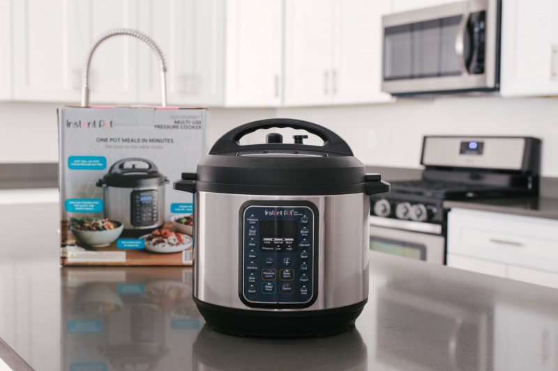 direct front shot of the Instant Pot Duo Gourmet on a gray countertop with the box and white cabinets in the background