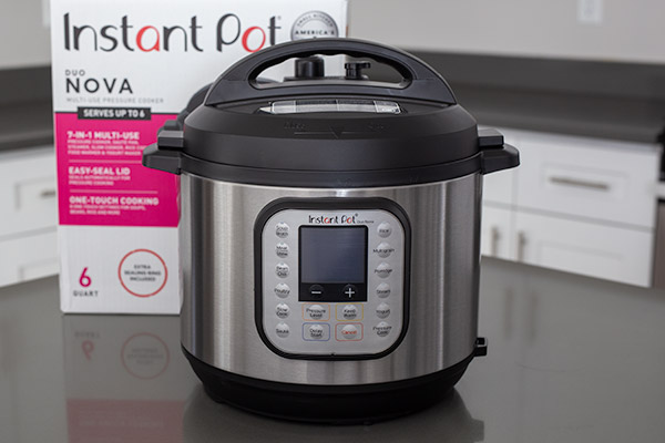 Instant Pot Duo Nova in front of the packaging box.