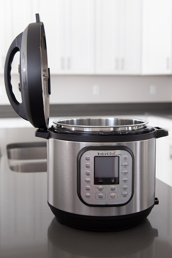 Instant Pot Duo Nova with the pressure cooker lid placed on the side holder.