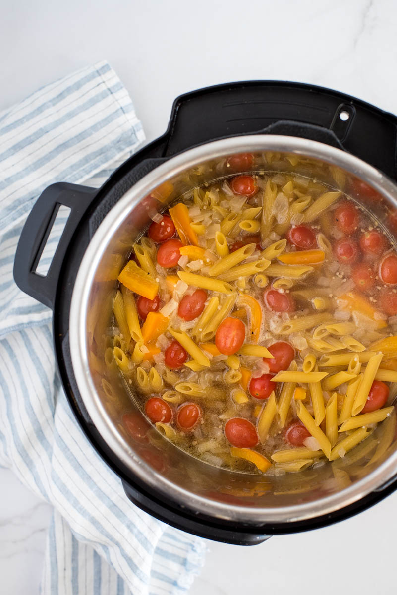 overhead of uncooked pasta primavera in an instant pot