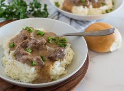 white bowl with swedish kalops beef stew over mashed potatoes