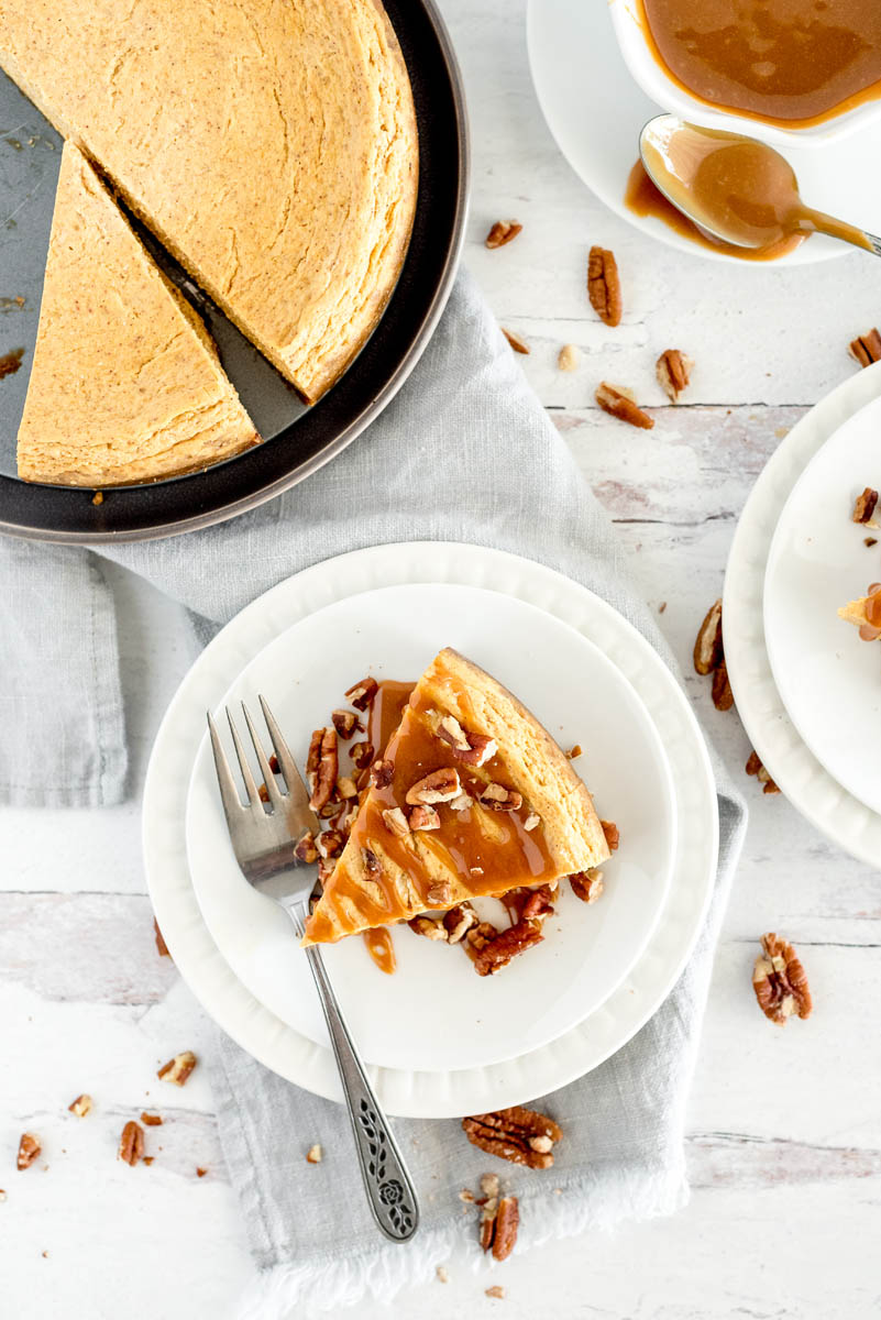 overhead of a slice of pumpkin cheesecake drizzled with caramel sauce