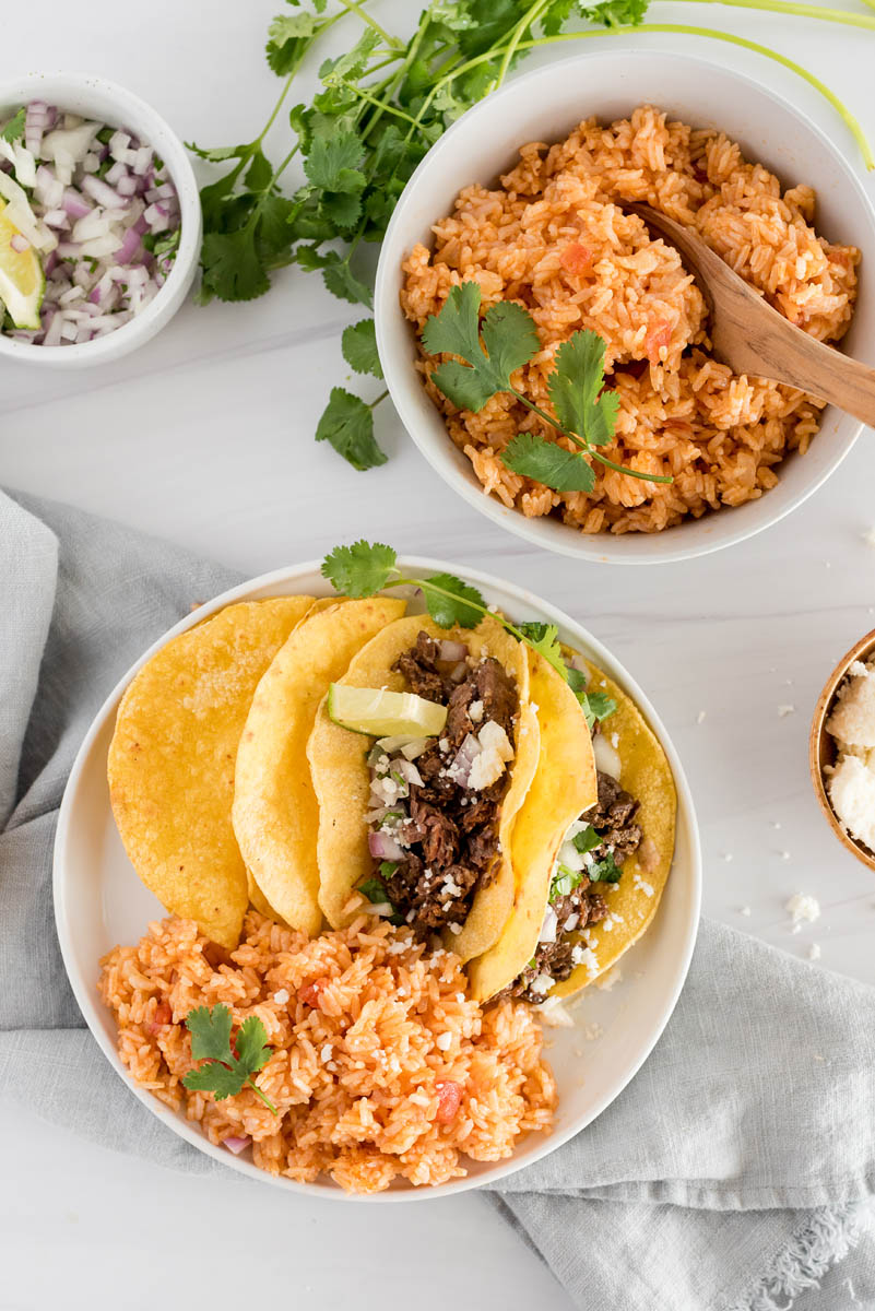 overhead of plates with spanish rice and tacos