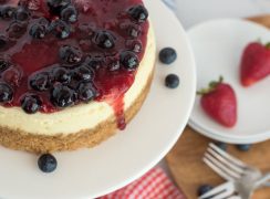Close up overhead shot of Instant Pot cheesecake topped with triple berry compote on a white cake stand