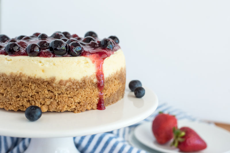 A closeup of fourth of July cheesecake made in an Instant Pot, and placed on a white cake stand.