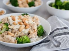 45 degree shot of rosemary cashew chicken served in a white bowl over rice and broccoli