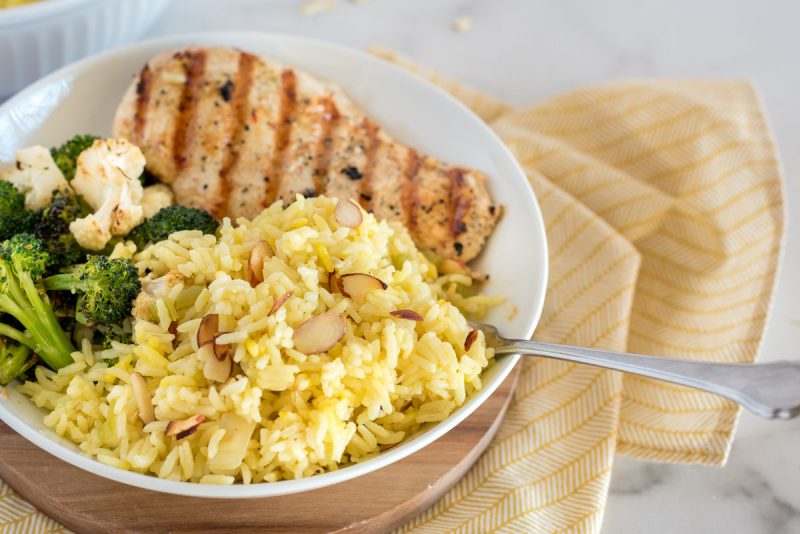 saffron rice pilaf with grilled chicken in a white bowl