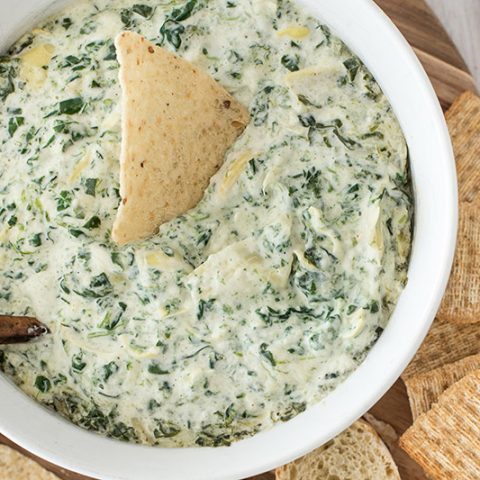 Hot spinach artichoke dip served with crackers and bread.