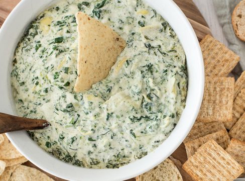 Hot spinach artichoke dip served with crackers and bread.