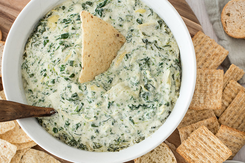 Hot spinach artichoke dip served with crackers and bread.