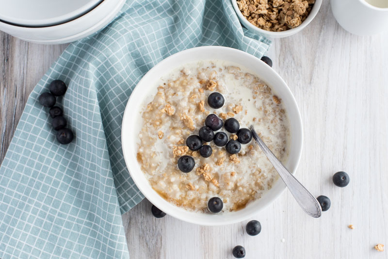 instant pot steel cut oats in a cereal bowl with granola and fresh blueberries