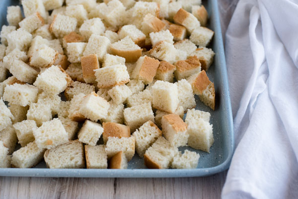 Cubed bread on a baking tray for making Insta Pot stuffing.
