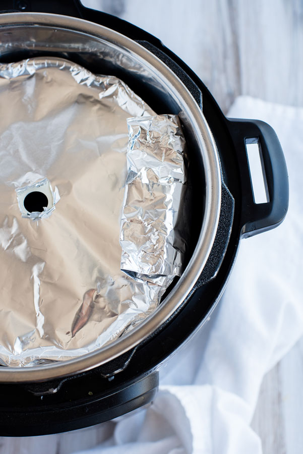 Half-sized bundt pan with Thanksgiving stuffing covered with foil and placed in an Instant Pot for pot in pot pressure cooking.