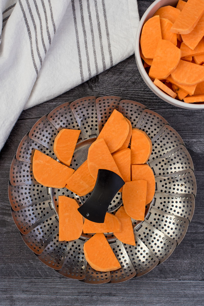 sweet potato slices on a metal steamer basket