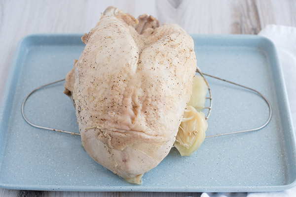 Fully cooked pressure cooker turkey breast resting on a baking tray.