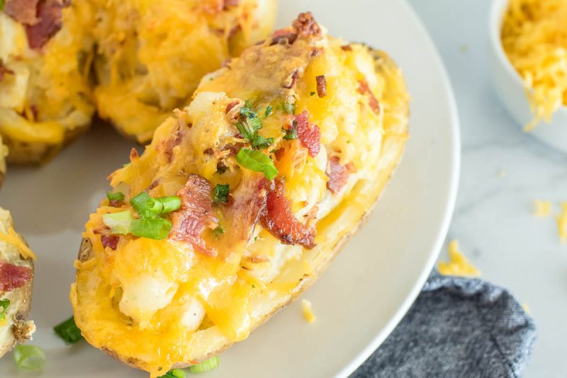 close up on an instant pot twice baked potato with ranch, bacon and scallions