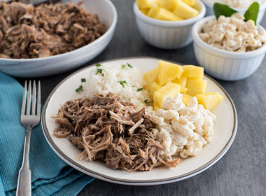 Insta Pot Kalua Pork recipe, plated and ready to serve with pineapple and macaroni and cheese