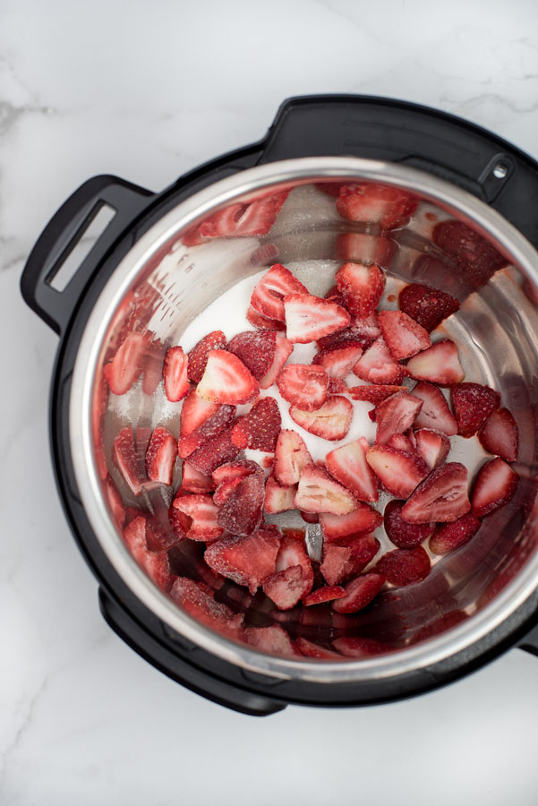 Strawberries, sugar, and lemon juice in an Instant Pot.