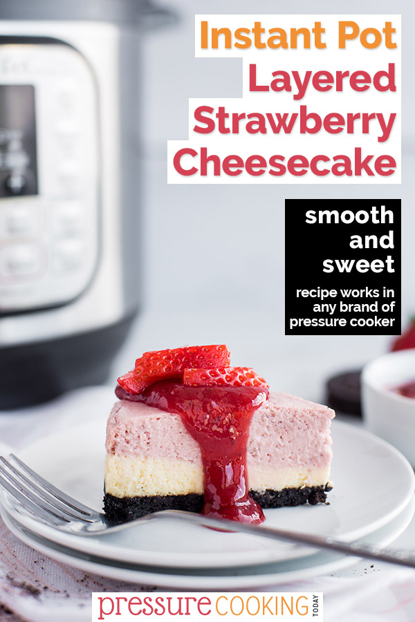 A slice of pink and white layered cheesecake topped with strawberries placed in front of an Instant Pot.