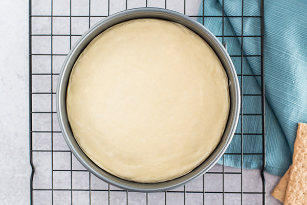 Pressure cooker cheesecake cooling to room temperature on a cooling rack.