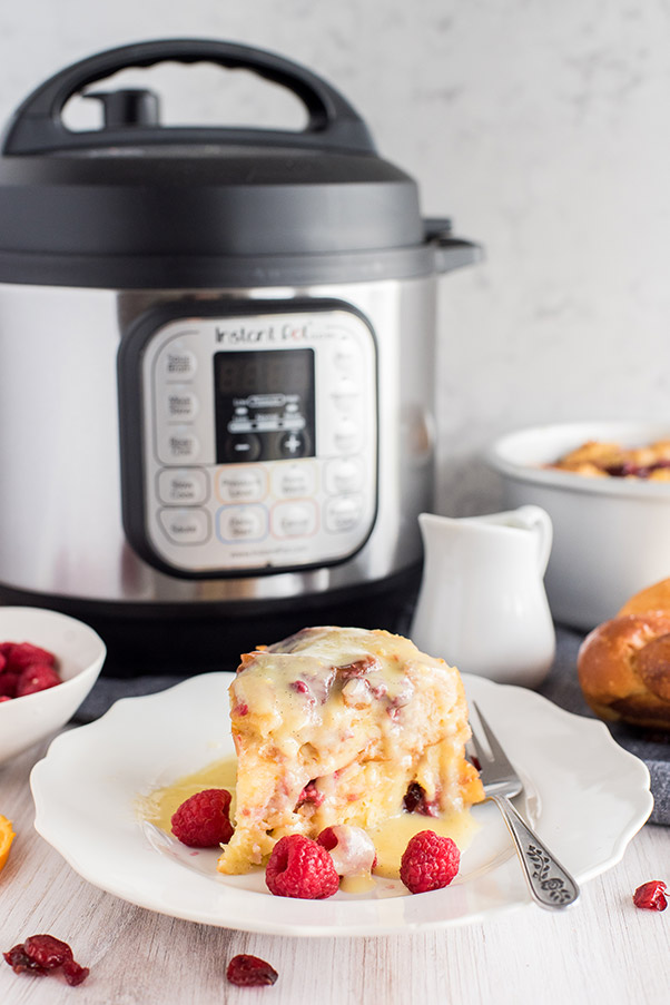 Instant Pot Raspberry Bread Pudding on a plate with Instant Pot in the background.