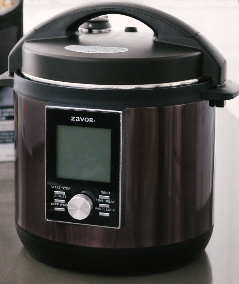 The black stainless steel Zavor Lux with an LCD screen placed on a kitchen counter.