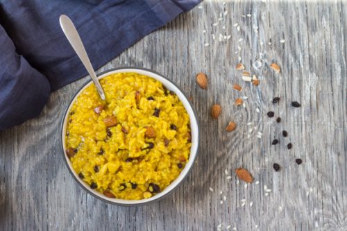 Instant Pot Saffron Risotto with Almonds and Currants in a bowl with a spoon