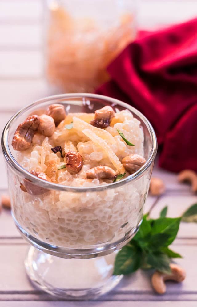 clear dessert cup with Pressure Cooker Coconut Lemongrass Ginger Tapioca garnished with cashews and crystallized ginger