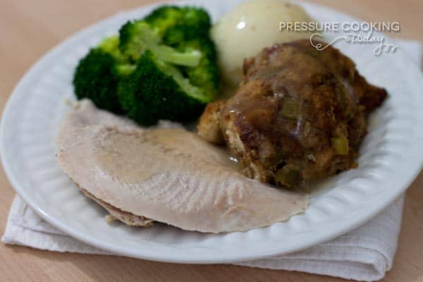 Moist and Tender Turkey Breast on a white plate with broccoli, mashed potatoes and stuffing