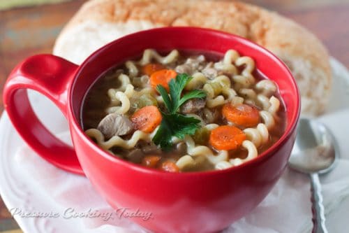 turkey noodle soup in a red bowl