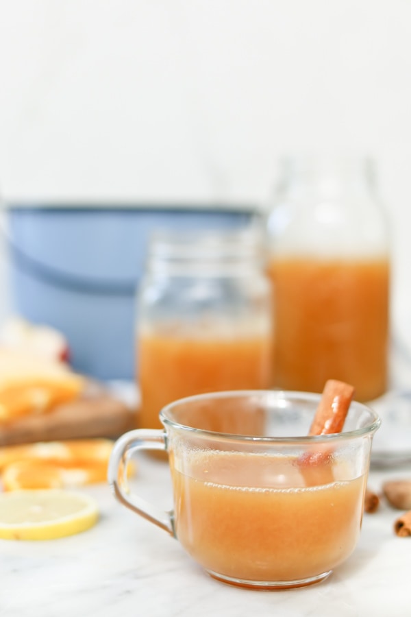 mug of electric pressure cooker wassail, garnished with a cinnamon stick